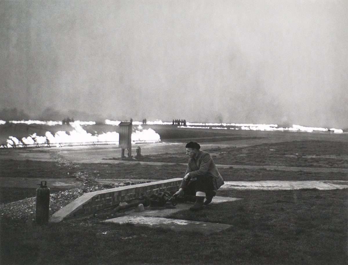 FIDO fire trenches burning along an airfield at dusk