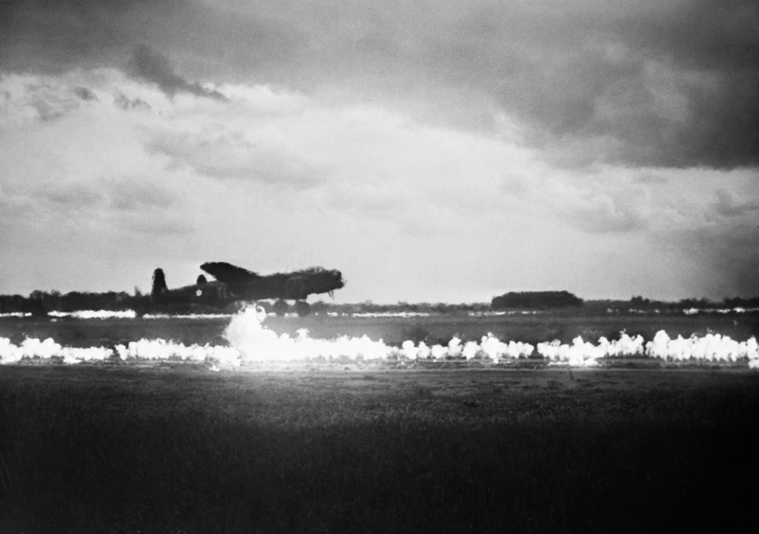 Avro Lancaster taking off between burning FIDO flame lines
